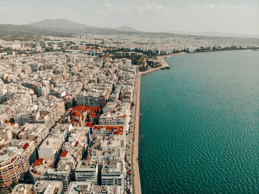 an aerial view of a city next to a body of water